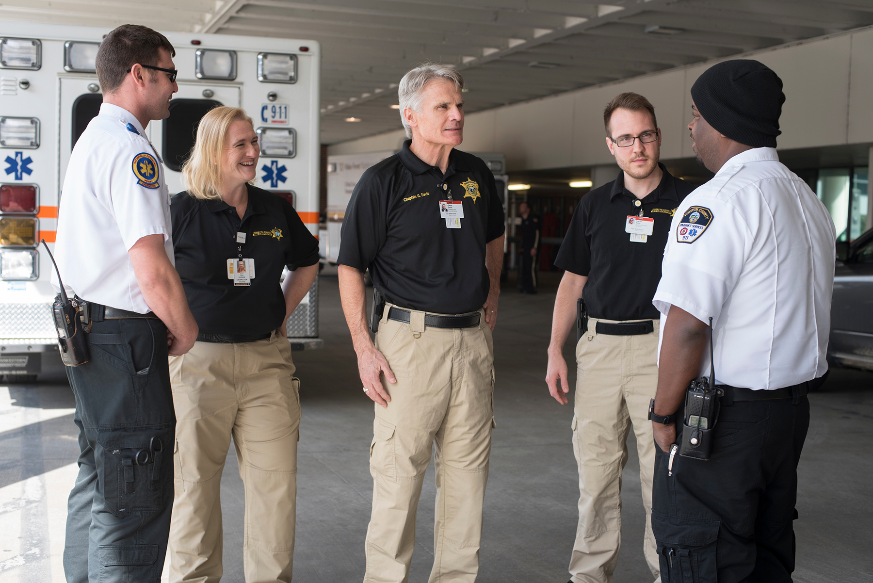 Administrative and non-clinical safety and security Group of security officers talking near ambulance